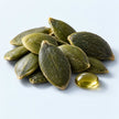 Pumpkin seeds beside a golden oil droplet